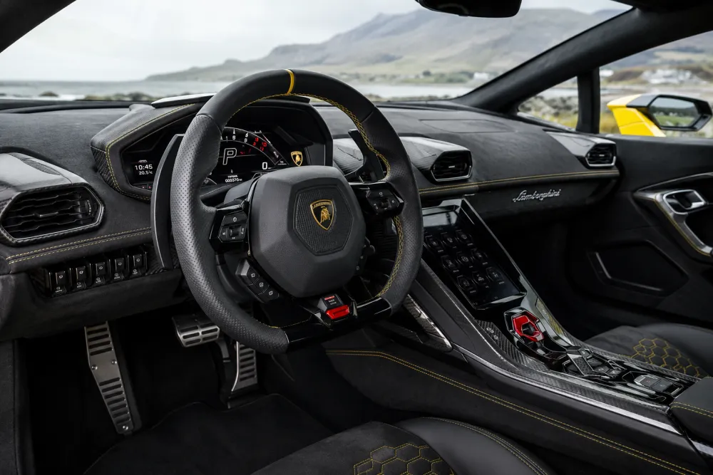 Lamborghini interior with carbon fiber dashboard trim, steering wheel details, and premium